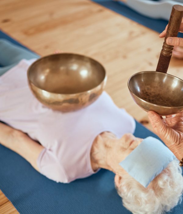 Singing bowls, meditation and senior woman on floor for healing, vibration and sound therapy with h.